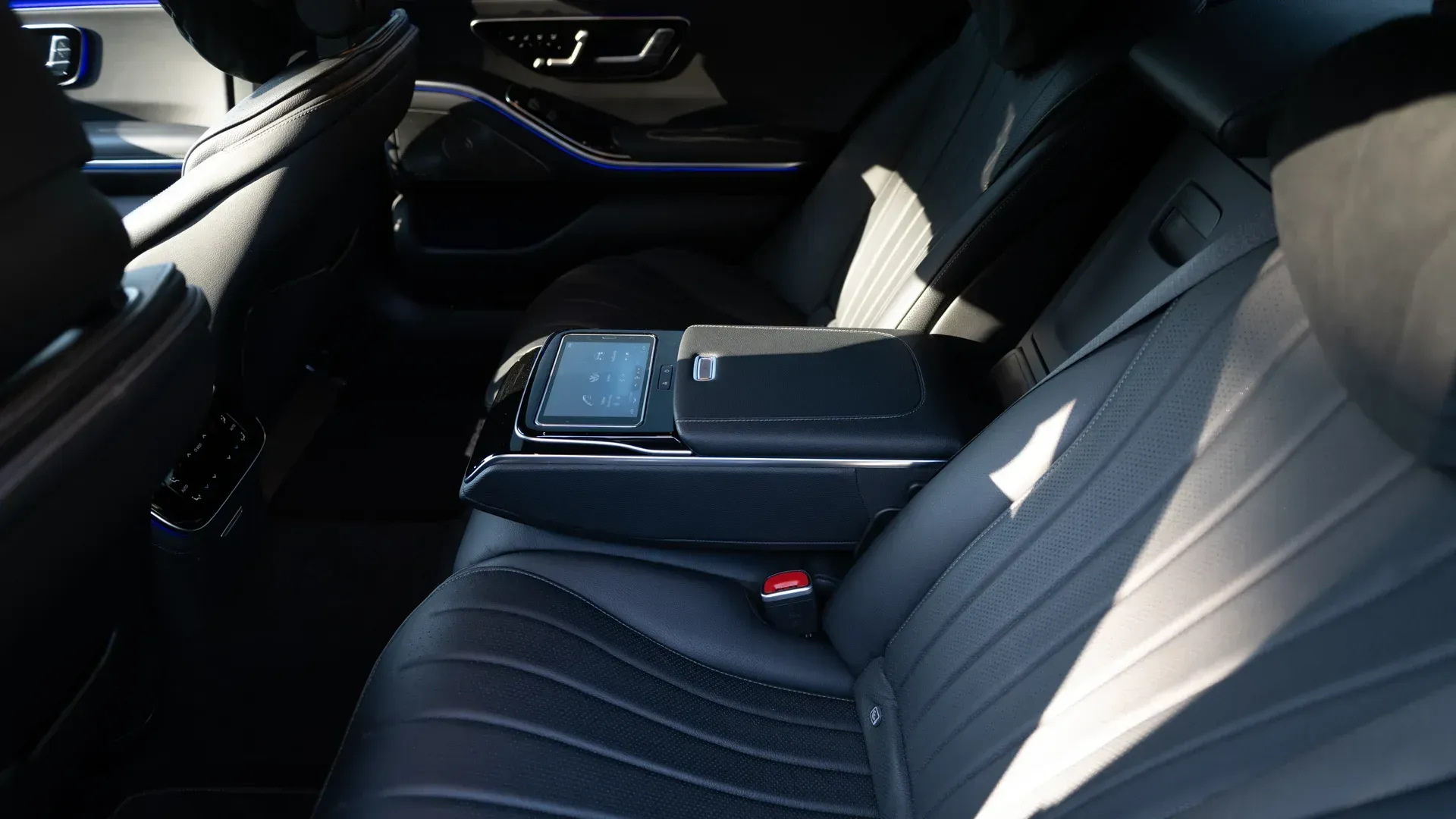 Rear passenger cabin with leather upholstery and a centre console.