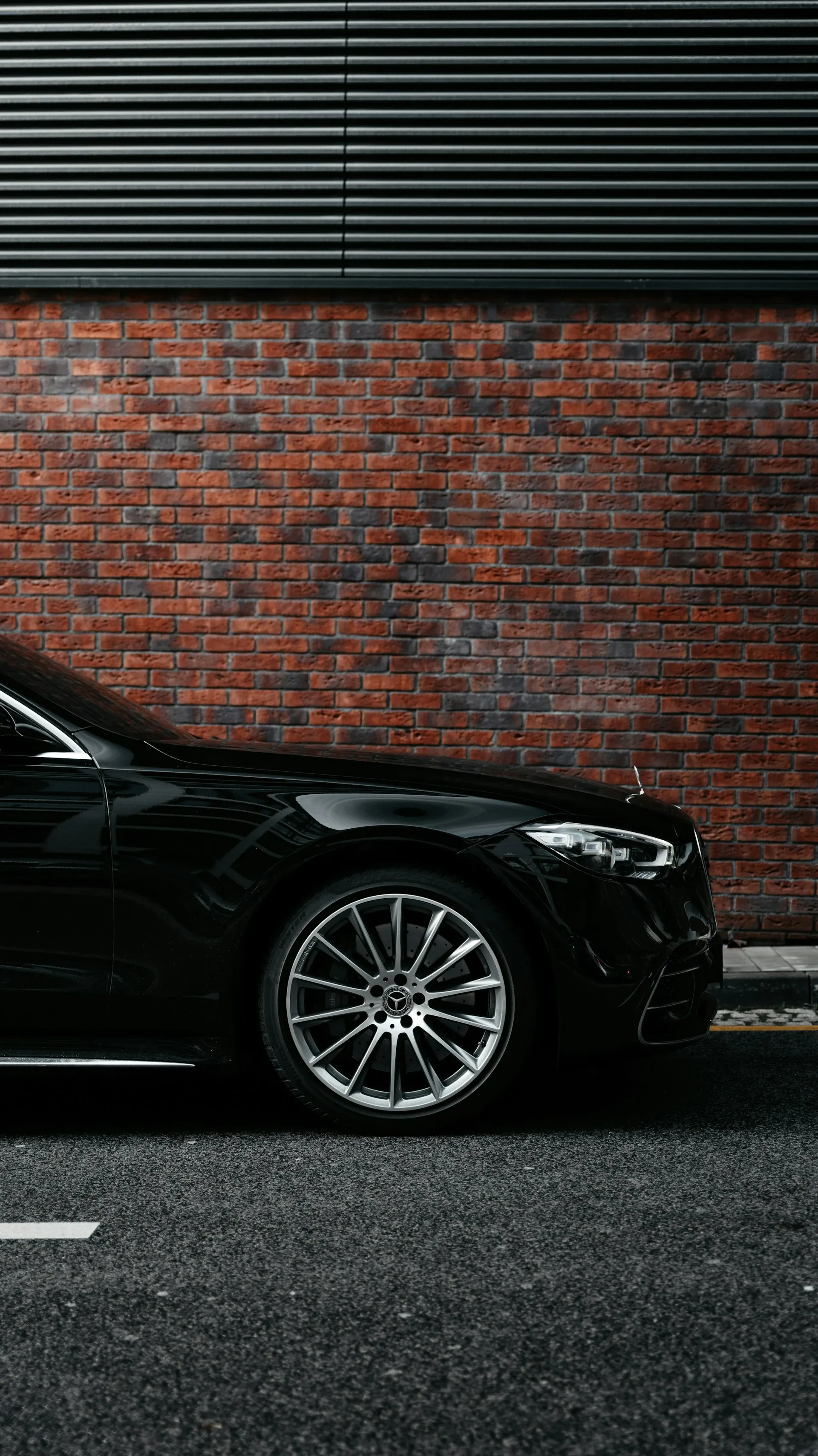 Black Mercedes-Benz S-Class beside a brick business building