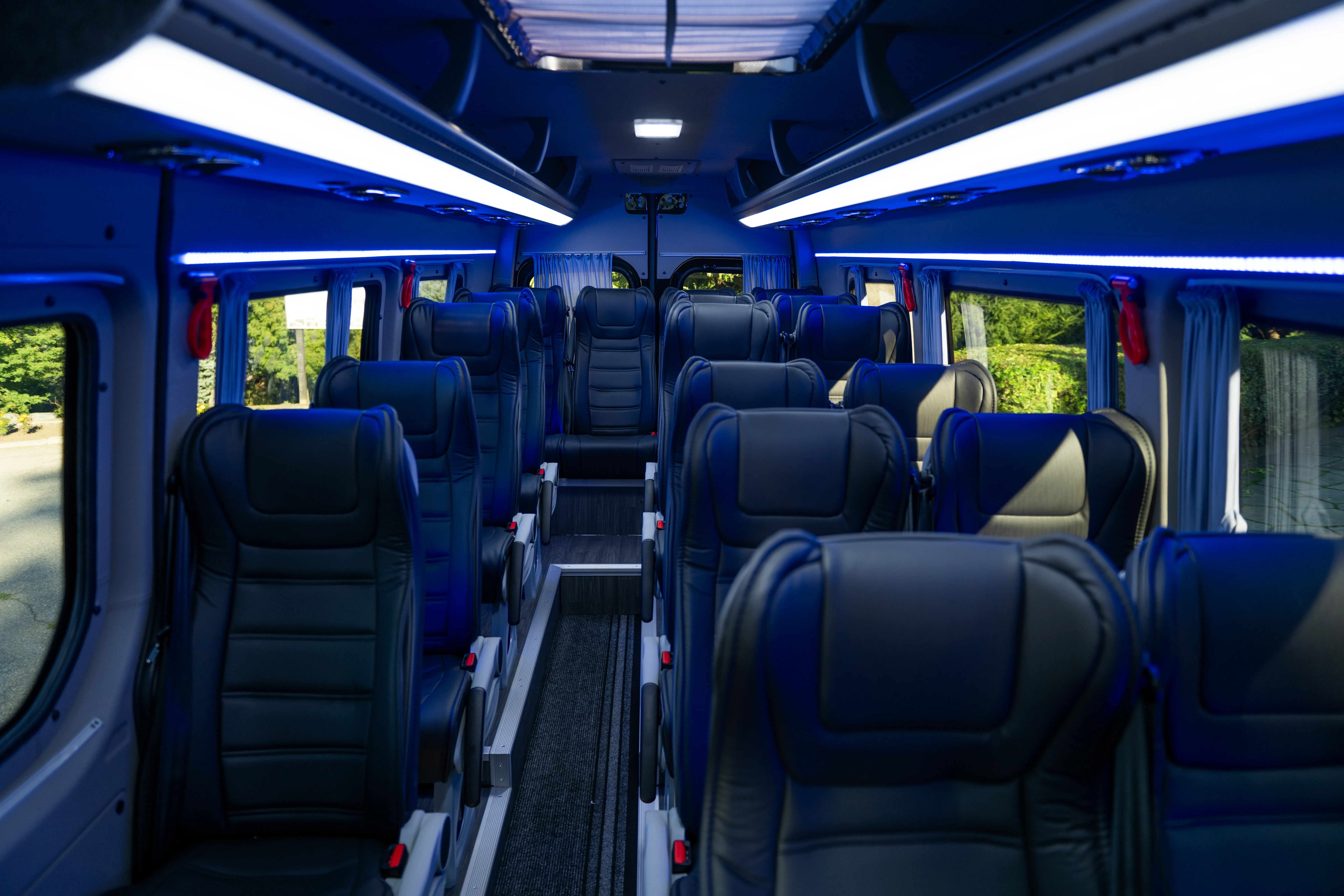 Rows of seats in a minibus cabin; group-transport reference, with configuration confirmed separately.