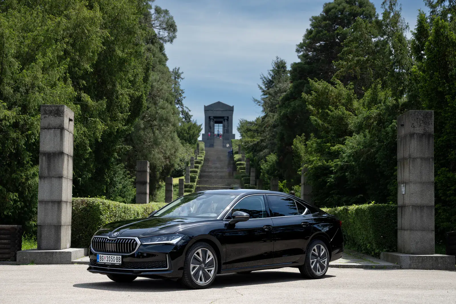 Black Škoda Superb viewed from the front and side.