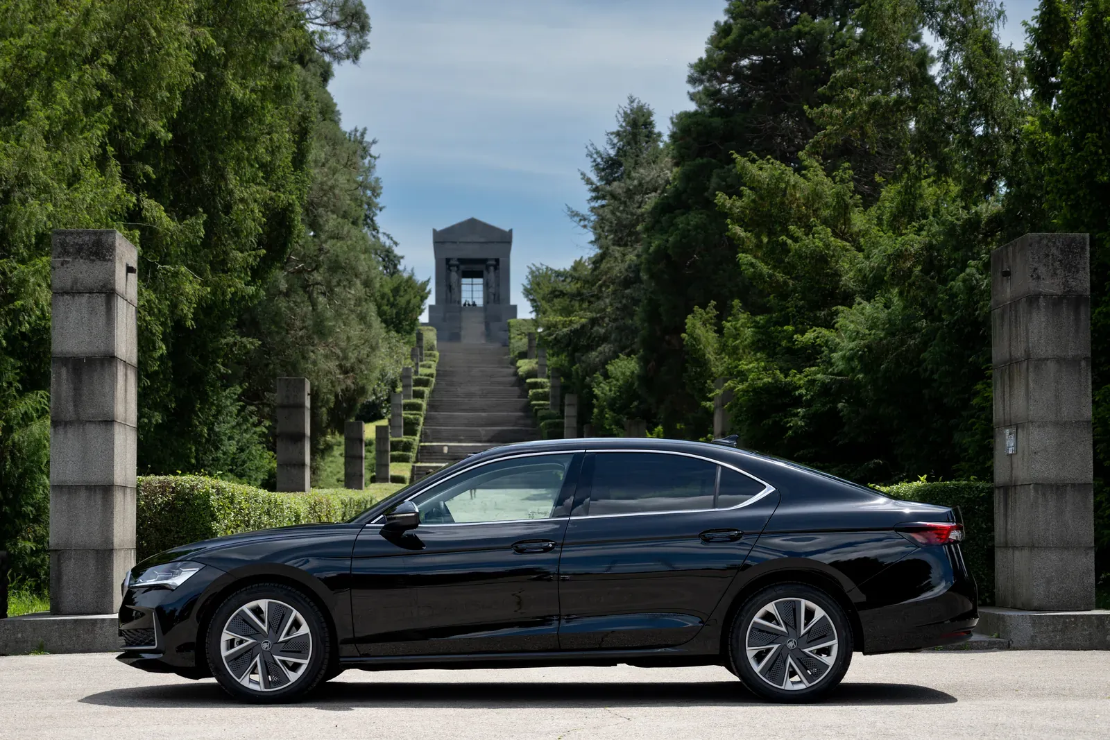 Black Škoda Superb viewed from the side.